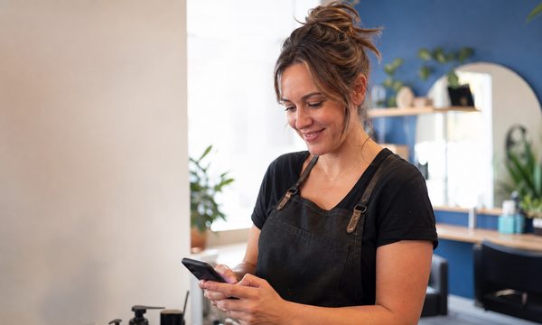 Coiffeuse consulte son horaire Confirmeo dans son salon